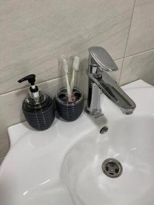 a bathroom sink with a faucet and tooth brushes at 20%off to Bakuriani amenities in Bakuriani