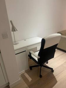 a black and white chair in a room with a desk at Stunning 2 Bedroom Apartment in London