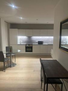 a large kitchen with a table and a dining room at Stunning 2 Bedroom Apartment in London