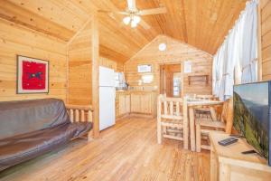 a log cabin living room with a couch and a table at The Blue Spruce Cabin #16 at Blue Spruce RV Park & Cabins in Tuckerville