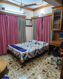 a bedroom with a bed and a desk and curtains at Dhanmondi Furnished Lake View Apartment in Dhaka