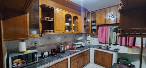 a kitchen with wooden cabinets and a microwave at Dhanmondi Furnished Lake View Apartment in Dhaka