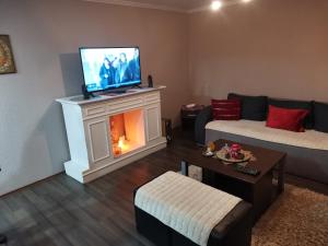 a living room with a fireplace with a tv on top at Vila Ivana in Krajišnići