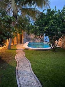 a garden with a stone path leading to a swimming pool at Casa Emilia in Yautepec