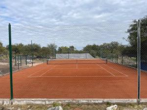 a tennis court with a net on top of it at Cabaña romántica en la sierra in Yacanto