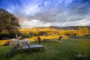 a group of chairs and a table in a yard at Cabaña romántica en la sierra in Yacanto