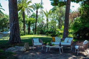 grupa krzeseł i stołów w ogrodzie z drzewami w obiekcie Castillo de Meng the Castle Experience w mieście Cabrils