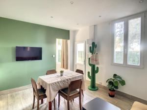 a dining room with a table with chairs and a tv at Appartement aux salins du lion in Vitrolles