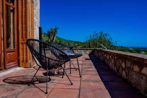 2 Stühle und ein Tisch auf der Terrasse in der Unterkunft Castillo de Meng the Castle Experience in Cabrils