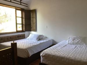 1 Schlafzimmer mit 2 Betten und einem Fenster in der Unterkunft Cabaña Villalmira in Iza