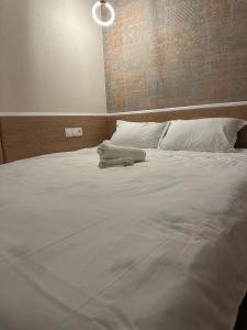 1 cama grande con sábanas y almohadas blancas en мини-отель Villa Sofia город Шымкент, проспект Тауке хана, жилой дом 37-2 этаж, en Shymkent