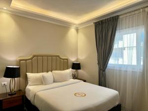 a bedroom with a bed with white sheets and a window at Fleet Club Mahrousa in Alexandria