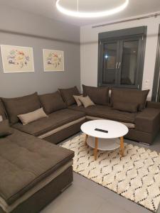 Square Apartments في تريكالا: غرفة معيشة مع أريكة وطاولة