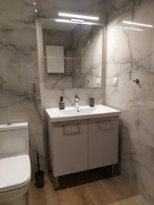a bathroom with a white sink and a toilet at Square Apartments 1 in Tríkala +31 photos