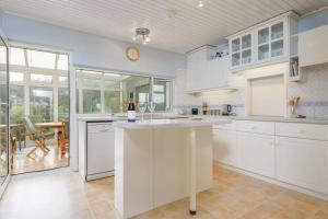 a kitchen with white cabinets and a table with a bottle of wine at Stunning River Views, Tranquil Split-Level House, Private Garden & Parking in Golant