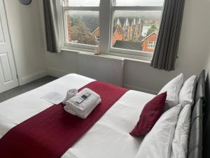 a bedroom with a bed with two towels and a window at River side rooms in Southampton