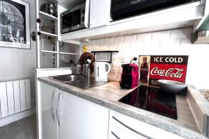 a kitchen with a cocacola sign on the counter at Cozy love cocoon in the heart of Paris 2nd in Paris