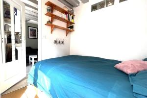 a bedroom with a blue bed in a room at Cozy love cocoon in the heart of Paris 2nd in Paris