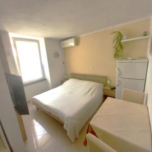 a small bedroom with a bed and a window at Apartment & studio Elizabet in Baška