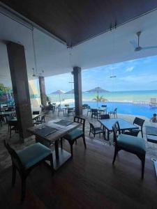 un restaurante con mesas y bancos y vistas al océano en Hotel poseidon piscina & jacuzzi, en Manta