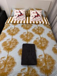 Una cama con colcha con palmeras. en Modern Studio Center of Dubai en Dubái