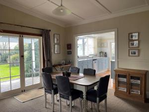 a kitchen and dining room with a table and chairs at Kosbys Cottage, Tongariro 