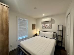 ein Schlafzimmer mit einem Bett mit weißen Laken und einem Fenster in der Unterkunft Tiger's Trail RV Resort in Baton Rouge + 27 Fotos