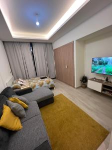 a living room with a couch and a flat screen tv at Modern Studio Center of Dubai in Dubai