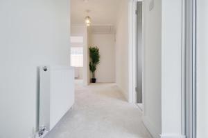 a hallway with white walls and a potted plant at 17 Banstead Road in Poole