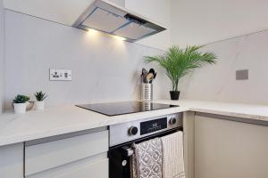 a white kitchen with a stove and a sink at 17 Banstead Road in Poole