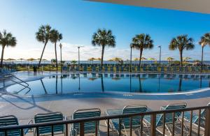 uma piscina com cadeiras e guarda-sóis e palmeiras em Dayton House Resort - BW Signature Collection em Myrtle Beach