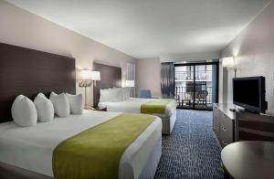 マートルビーチにあるデイトン ハウス リゾートのベッド2台、薄型テレビが備わるホテルルームです。