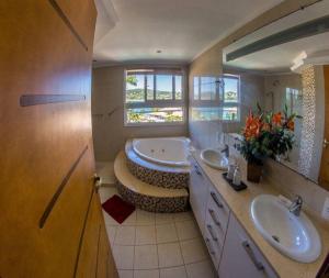 uma casa de banho com 2 lavatórios e um espelho grande em Maravilhosa Mansão em Frente à Praia da Ferradura Por Luxury Rentals em Búzios