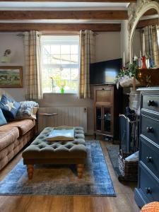 a living room with a couch and a table at Hideaway Cottage in Whitby