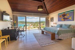 um quarto com uma cama e vista para o oceano em Maravilhosa Mansão em Frente à Praia da Ferradura Por Luxury Rentals em Búzios