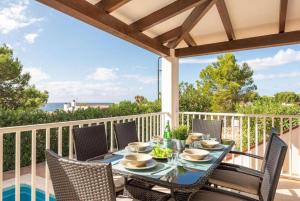 a table and chairs on a balcony with a view of the ocean at Villa Binilisa in Binibeca