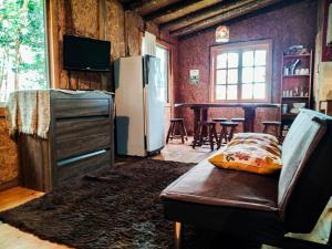 a living room with a refrigerator and a couch at Hostal & Cabañas Luna del Sur in Cucao