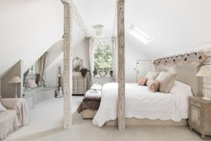 a white bedroom with a canopy bed and a staircase at Magical and Romantic Countryside Getaway Near Windsor Castle in Old Windsor