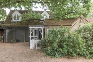 a house with a gate and a garage at Magical and Romantic Countryside Getaway Near Windsor Castle in Old Windsor