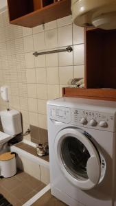 a kitchen with a washing machine in a kitchen at M&M Airport stop Garden Apartment in Spáta