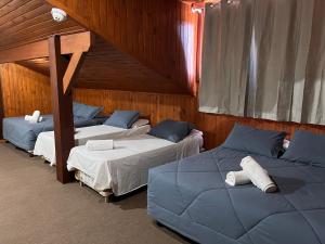 Habitación con 3 camas en una habitación en Pousada Suíça, en Canela