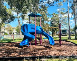 a playground with a blue slide in a park at 15 min to Disney World, Self-check-in, Full Kitchen in Kissimmee