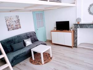 uma sala de estar com um sofá e uma mesa em Appartement cosy centre-ville. em Perpignan