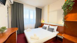 une chambre d'hôtel avec un lit avec deux chaussures dans l'établissement Dezudava Family Hotel, à Sandanski