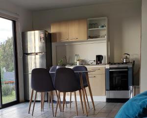 uma cozinha com uma mesa e cadeiras e um frigorífico em Cabaña Puro Ranco em Lago Ranco
