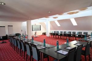 a conference room with tables and chairs and a screen at DAS WESEL - DEIN HOTEL AM RHEIN in Oberwesel