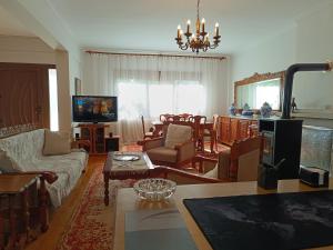 a living room filled with furniture and a tv at Cozy Garden House in Árgos Orestikón