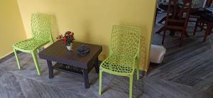 2 sillas y una mesa en una habitación con mesa y mesa en Villa westcost tembewadda colomb, en Canacona
