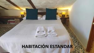 ムルシアにあるAlojamientos La Casa de Piedraのベッドルーム1室(ベッド1台、タオル2枚付)