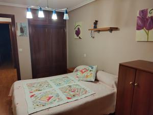 a bedroom with a bed with a quilt on it at Piso el castillo in Medina de Pomar